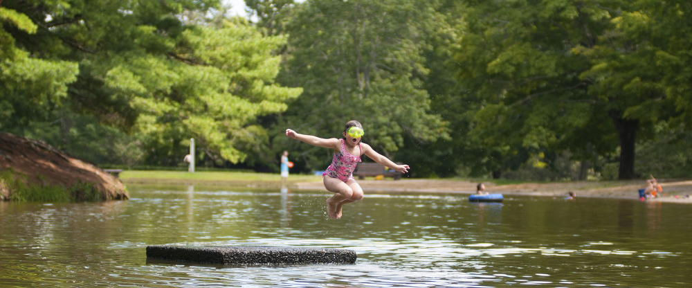 Child jumping into lake at Mashamoquet State Park
