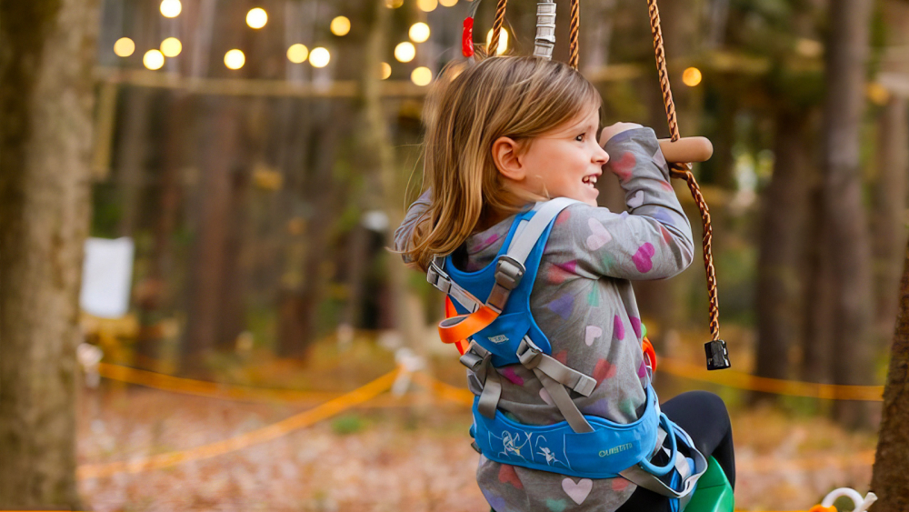 Young girl swinging on zip line at Tree Trails in Mystic CT