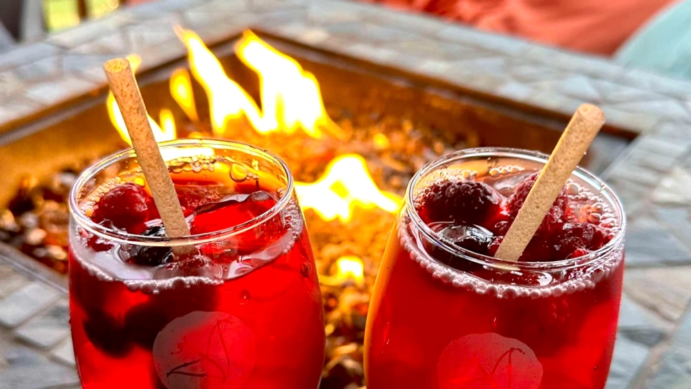 Dos bebidas rojas con temática de San Valentín frente a una fogata