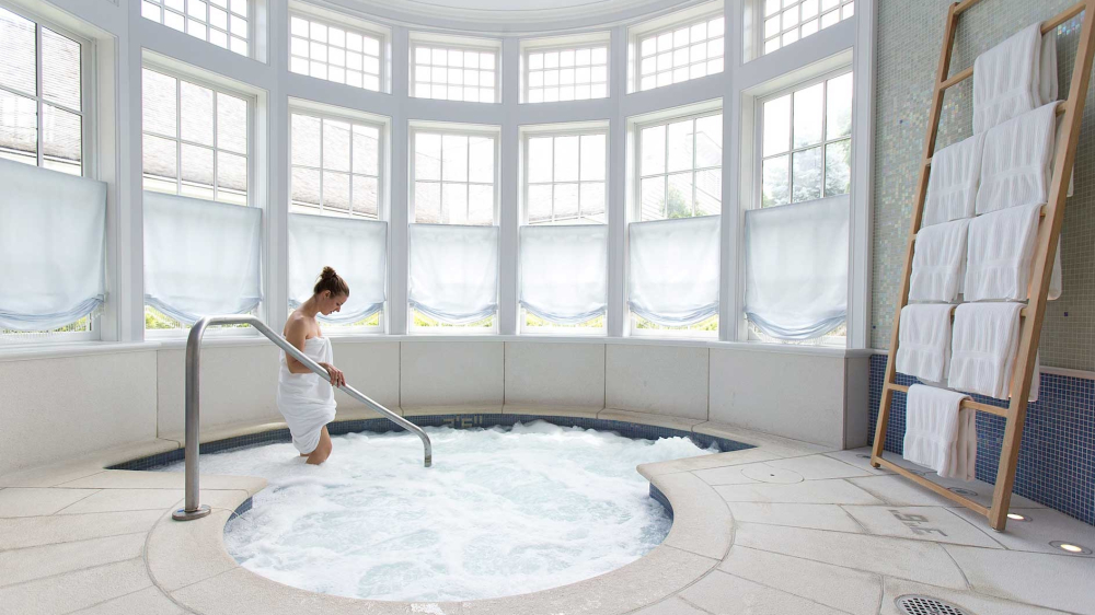 A spa guest steps into a whirlpool at the Mayflower Spa in Washington, CT