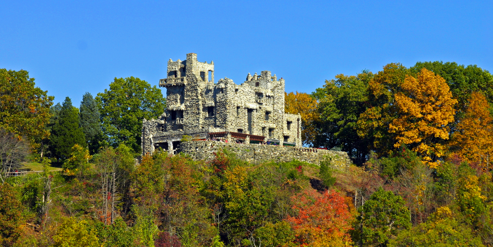 Stone castle ruin on hill surrounded by colorful autumn trees