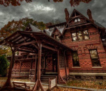 Victorian brick house under cloudy sky in autumn with wooden porch