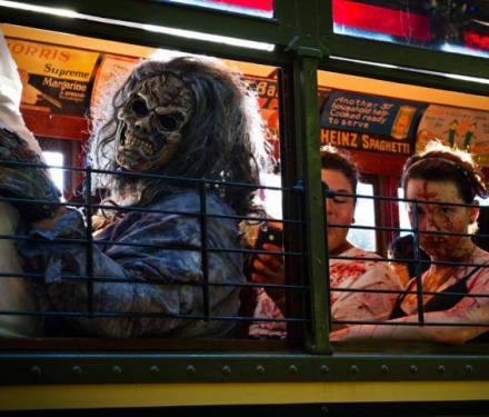 People in gruesome zombie costumes sitting inside a trolley car