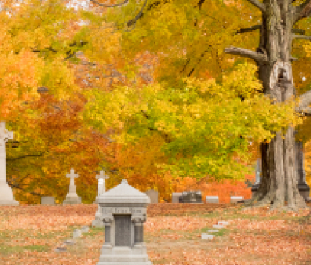 Autumn cemetery with tombstones and colorful fall foliage
