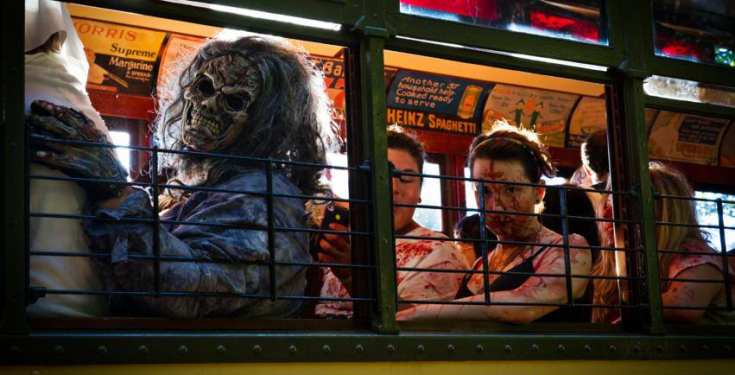 People in gruesome zombie costumes sitting inside a trolley car
