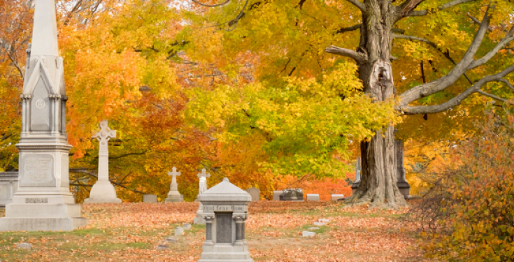 Autumn cemetery with tombstones and colorful fall foliage