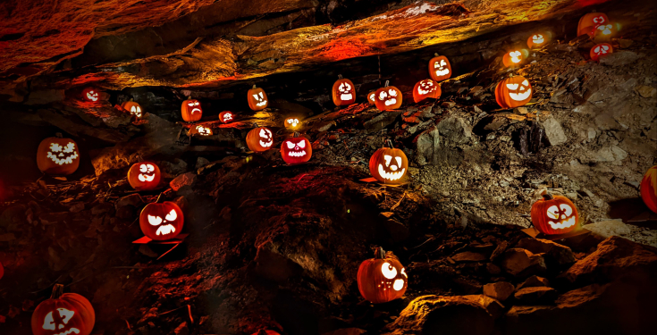 20 lit Jack O' Lanterns displayed in the underground caverns of the copper mine at Old New-Gate.