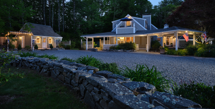 The main house and cottage at Abbey's Lantern Hill Inn illuminated at dusk