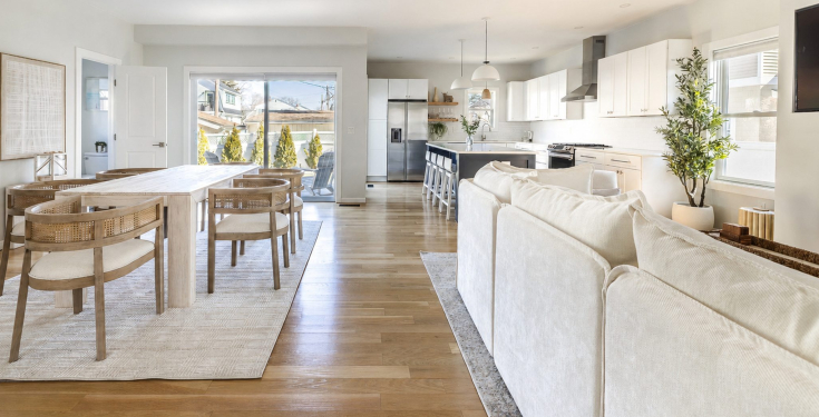 Sunlit open-plan living and dining area with 9-foot ceilings, wide-plank hardwood floors and a chef’s kitchen 
