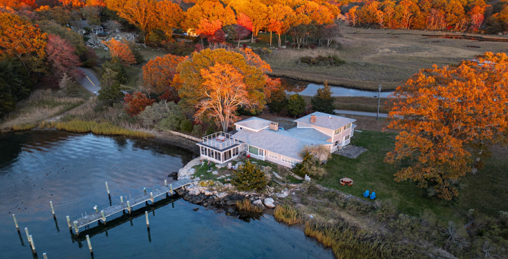 Aerial view of 26 Schoolhouse at the edge of the Mystic River, amid autumn marsh and trees